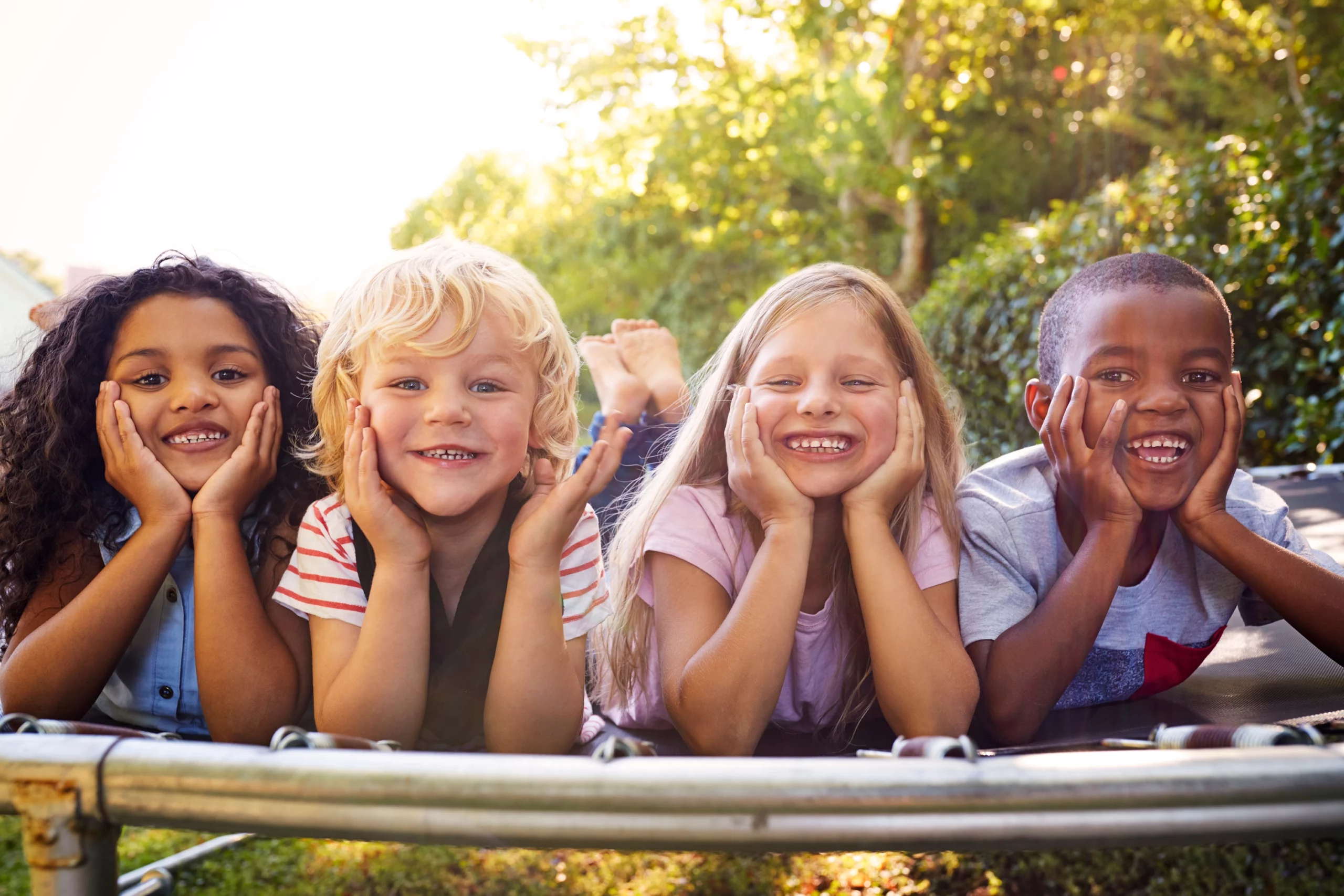 Diverse group of children smiling on a trampoline