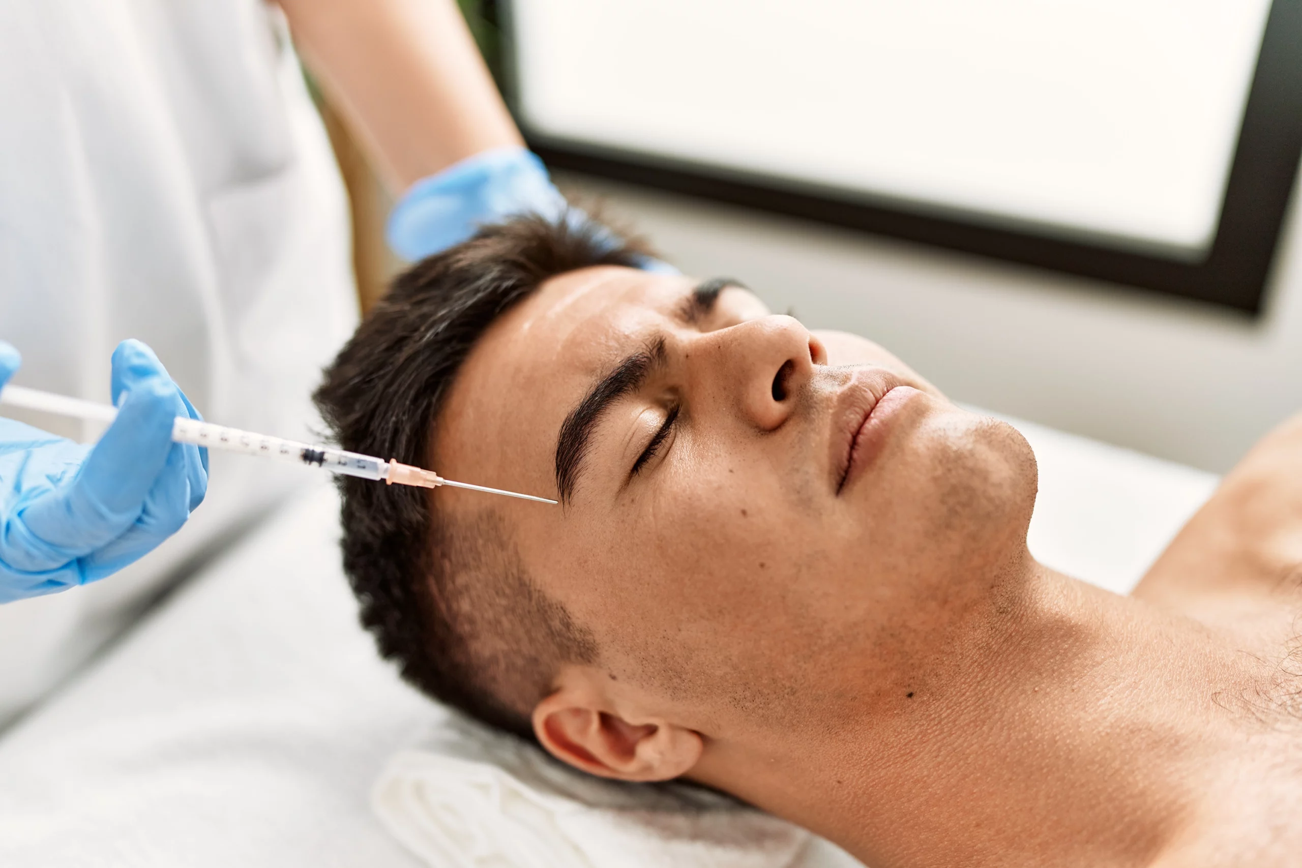 Man getting Botox injections to his forehead